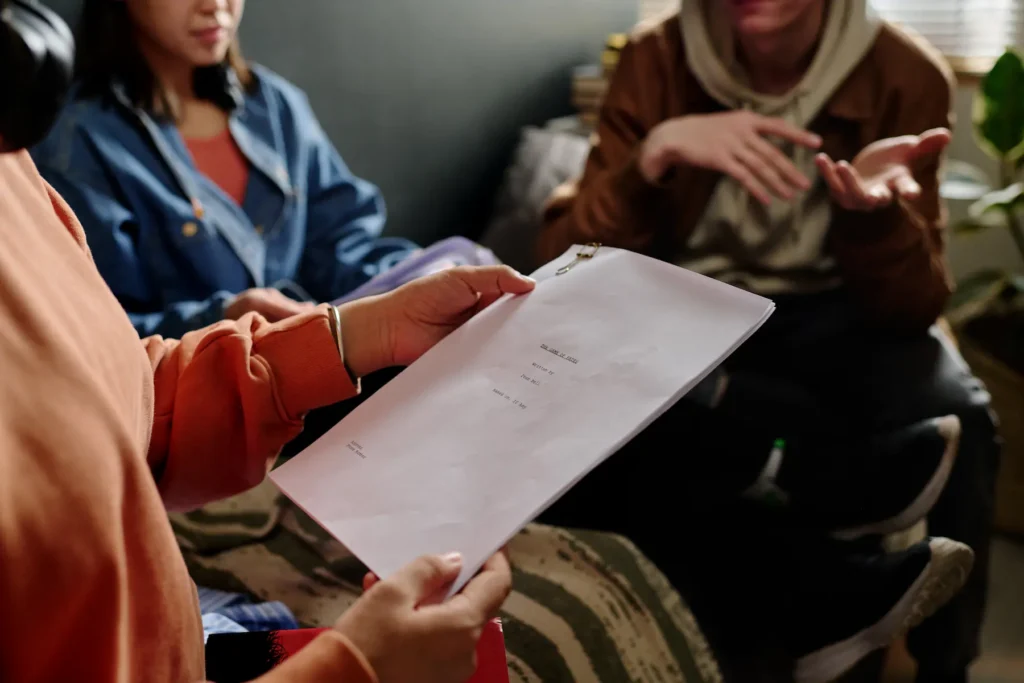 Guionista escribiendo en un guion gráfico con notas y storyboard en una mesa de trabajo